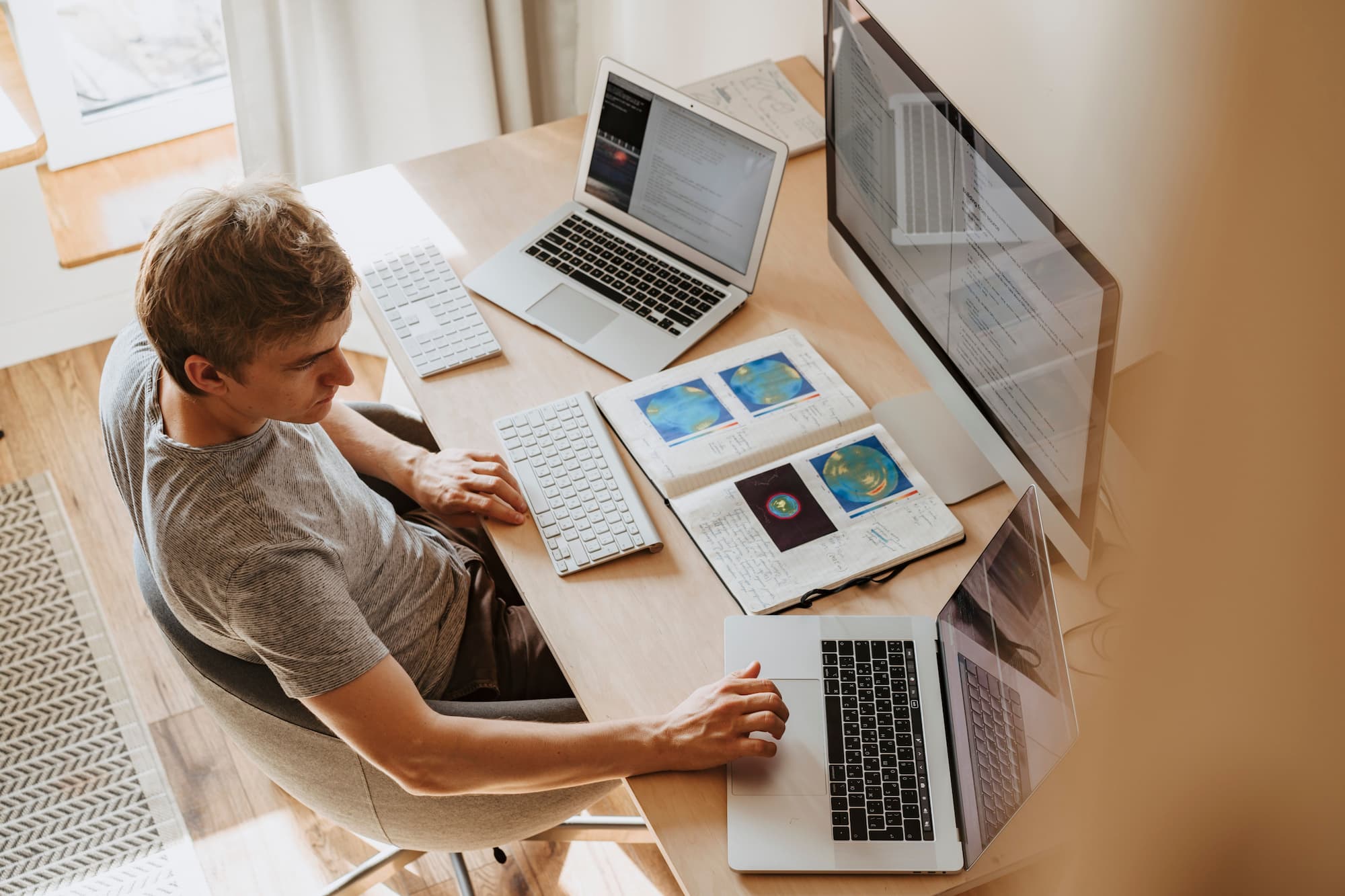 A laptop and notebook on a kitchen table
